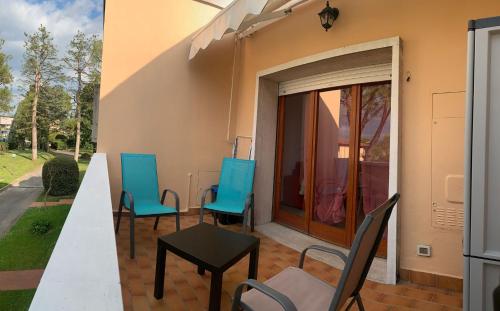 eine Terrasse mit Stühlen, einem Tisch und einer Tür in der Unterkunft Vita Loca Apartments in Peschiera del Garda