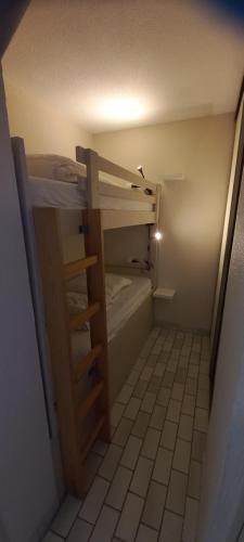 um pequeno quarto com 2 beliches num quarto em Appartement situé au Cap d'Agde proche plage em Cap d'Agde