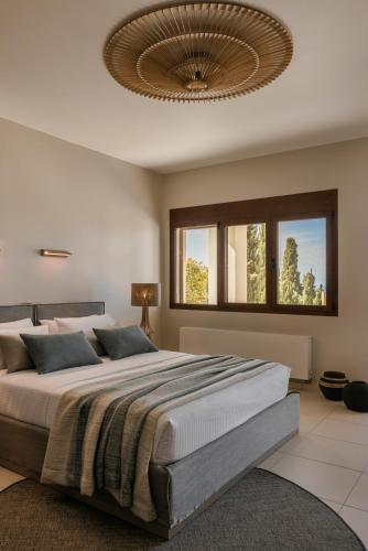 a bedroom with a large bed with a ceiling at Luxury Villa Karmaniolos Fiskardo Kefalonia in Fiskardho
