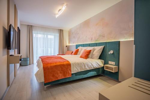 una camera da letto con un grande letto con una coperta arancione di Viktória Apartman a Gyula