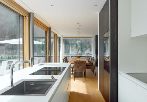 a kitchen with a sink and a dining room with a table at Design Villa M by Pferd auf Wolke in Gortipohl