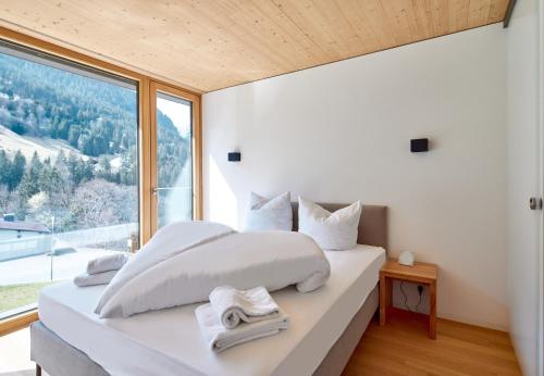 a bedroom with a white bed with a large window at Design Villa M by Pferd auf Wolke in Gortipohl