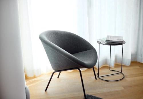 a gray chair and a side table in a room at Design Villa M by Pferd auf Wolke in Gortipohl