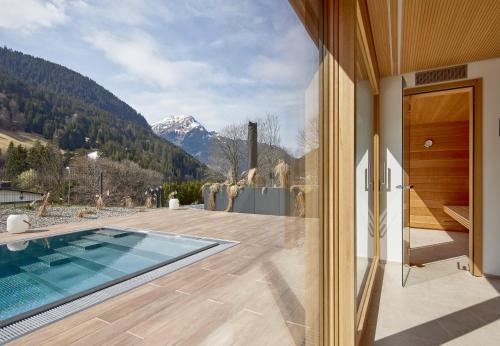 a house with a swimming pool and a view of a mountain at Design Villa M by Pferd auf Wolke in Gortipohl