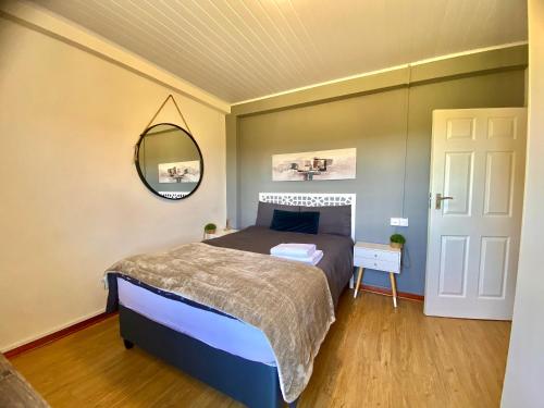 a bedroom with a bed and a mirror on the wall at The Ultimate Escape - Backup Electricity in Gaborone