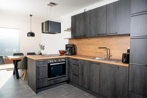 a kitchen with gray cabinets and a sink and a table at Living797 in Albstadt