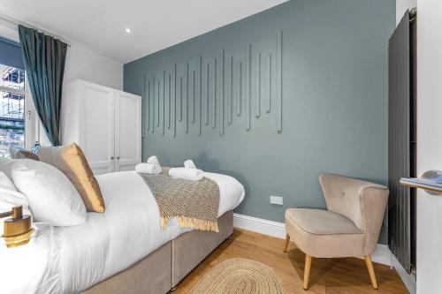 a bedroom with a bed and a chair at Jamson Pl Apartment in Edinburgh