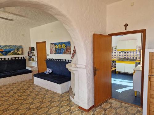 ein Wohnzimmer mit einem Sofa und einem Eingang in der Unterkunft Casa Cicci in pole position di fronte al mare in Marina di Sorso