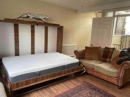 a bedroom with a bed and a couch in a room at Cosy and Stylish 1BD-Limehouse in London