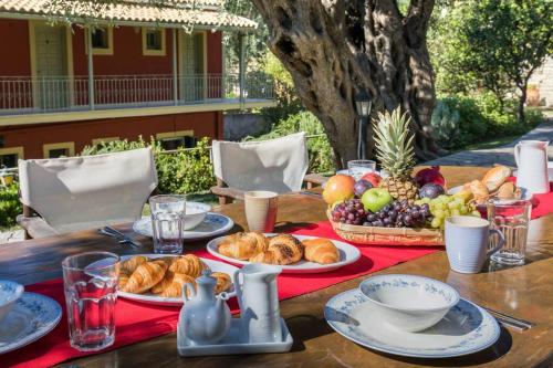 einen Tisch mit Brotplatten und Obst darauf in der Unterkunft Villa Anthoussa in Palaiokastritsa in Korfu-Stadt