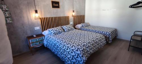 1 dormitorio con 2 camas, mesa y luces en AniCa II, el lugar de la Mancha en Argamasilla de Alba