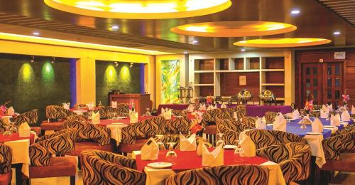 a banquet hall with tables and chairs with zebra patterned chairs at DESHA TARC in Kushtia