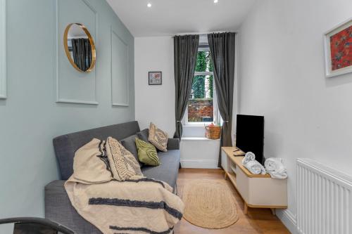 a living room with a couch and a tv at Jamson Pl Apartment in Edinburgh