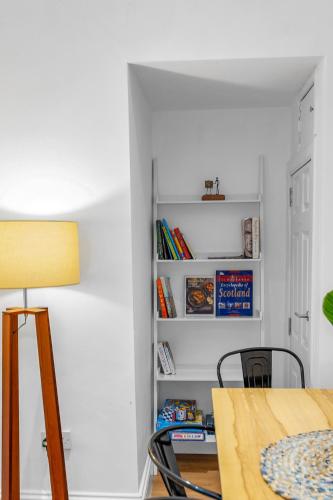 a dining room with a table and a book shelf at Jamson Pl Apartment in Edinburgh