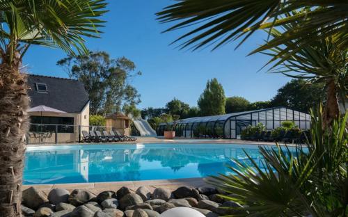 une piscine devant une maison dans l'établissement Mobil-home 6 Personnes - Bretagne - Piscine - Plage, à Trégunc