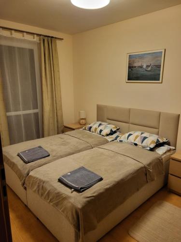 een slaapkamer met een groot bed en 2 handdoeken bij Amber in Międzywodzie