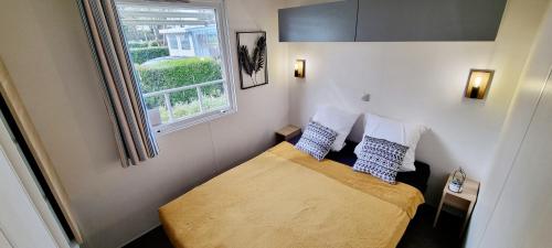 une petite chambre avec un lit et une fenêtre dans l'établissement Mobil-home 6 Personnes - Bretagne - Piscine - Plage, à Trégunc
