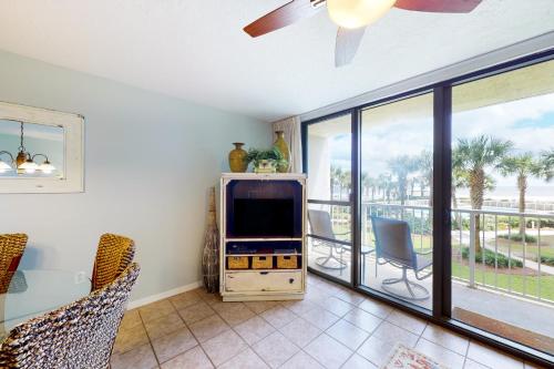 a living room with a tv and a balcony at Seaside Beach & Racquet Club 5215 in Orange Beach