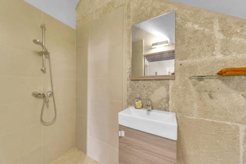 La salle de bains est pourvue d'une douche, d'un lavabo et d'un miroir. dans l'établissement charmantes und modernes Stadthaus Casa Corazon, à Santanyí