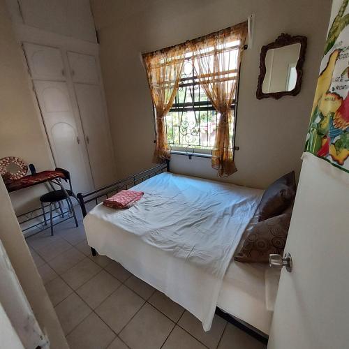 a small bed in a room with a window at River View in Micoud