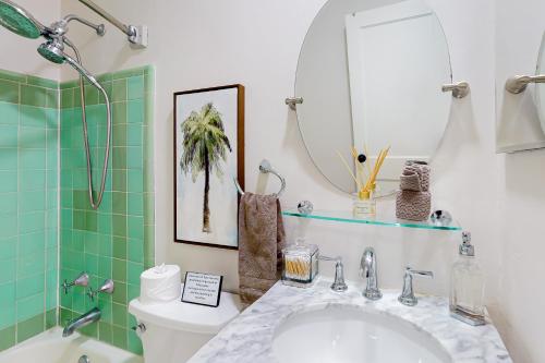 a bathroom with a sink and a toilet and a mirror at Northwood Charmer in West Palm Beach