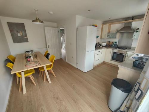 a kitchen and dining room with a table and chairs at Shoreline Seaside Holiday Home Aberavon beach in Port Talbot