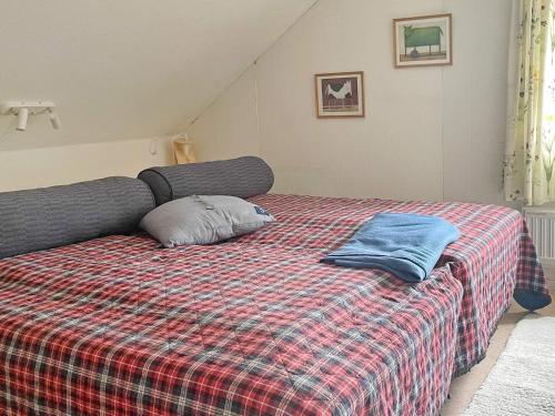 uma cama com um cobertor xadrez e duas almofadas em Holiday home ULRICEHAMN VI em Ulricehamn