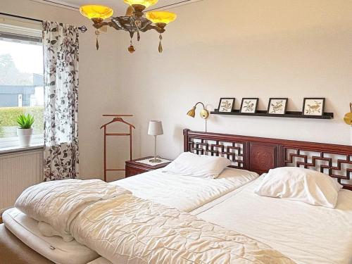 瑟爾沃斯堡的住宿－Holiday home SÖLVESBORG XII，一间卧室设有两张床、一个窗户和一个吊灯。