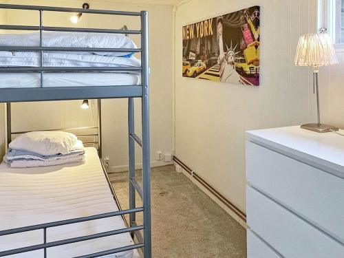 a bedroom with bunk beds and a desk with a lamp at Holiday home RAA HELSINGBORG in Pålstorp