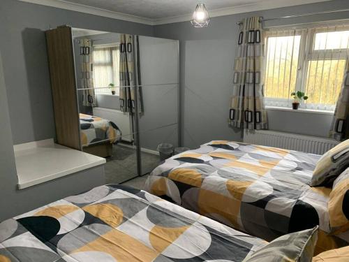 a bedroom with two beds and a mirror at Stylish, cosy, home with off-road parking 