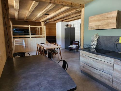 a kitchen with a table and a dining room at La Fessette in Chapelle-des-Bois