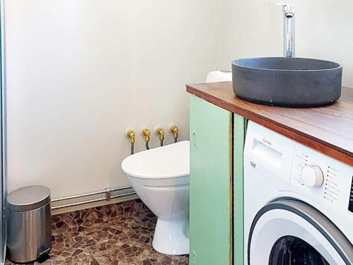 ein Badezimmer mit einem WC und einer Waschmaschine in der Unterkunft Holiday home Bureå in Bureå