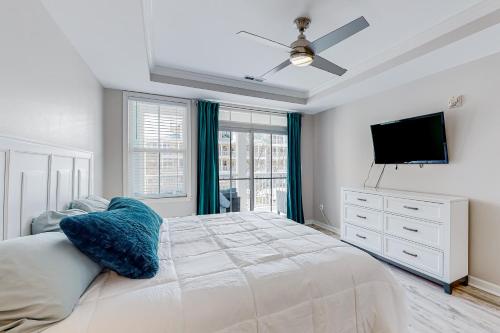 ein weißes Schlafzimmer mit einem Bett und einem TV in der Unterkunft Sunset Island - 37 Fountain 2D in Ocean City
