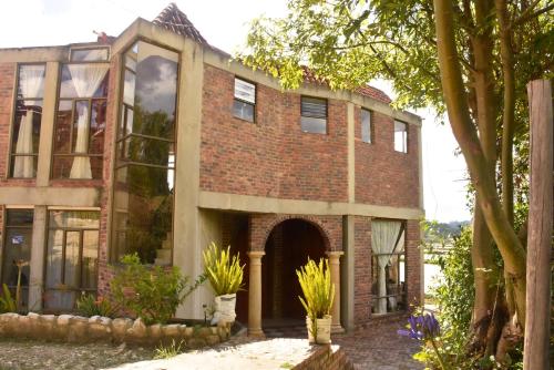 un bâtiment en briques avec une arche et des plantes dans l'établissement Hotel Campestre Villa Los Duraznos, à Paipa