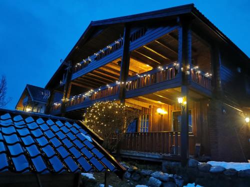 a house with christmas lights on the front of it at Loghouse apartment in arctic wonderland! in Kvaløya