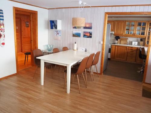a white dining room table and chairs in a kitchen at Loghouse apartment in arctic wonderland! in Kvaløya