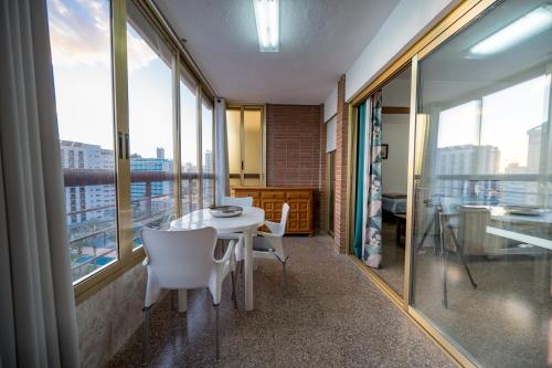 ベニドルムにあるOne bedroom Flat with shared pool in Acuarium IIのテーブルと椅子と窓のあるダイニングルーム