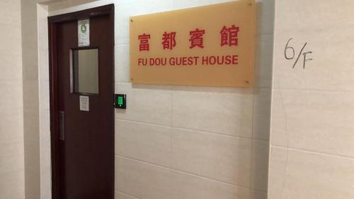 un panneau sur le mur d'une maison d'hôtes hospitalière dans l'établissement 富都賓館 Fu Dou Guest House, à Hong Kong