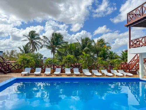 a pool at a resort with lounge chairs and palm trees at Vila Jeri Hotel in Jericoacoara