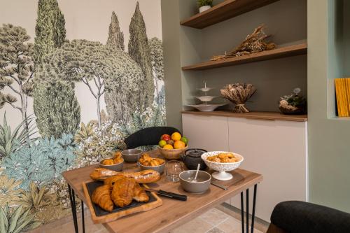 a table with bread and other food on it at Les clés d'à côté - maison d'hôtes de charme près de Rouen in Sotteville-lès-Rouen