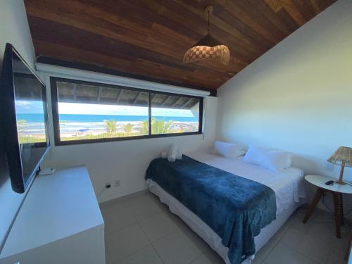 a bedroom with a bed with a view of the ocean at Bangalô Porto Galinhas in Porto De Galinhas