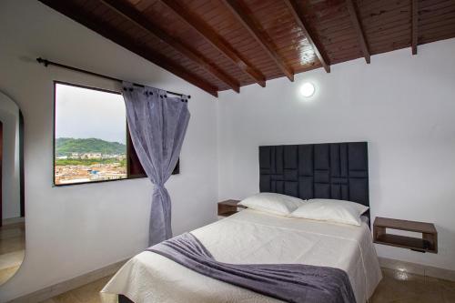 a bedroom with a large bed and a window at Espectacular casa cerca a parques turisticos in Medellín