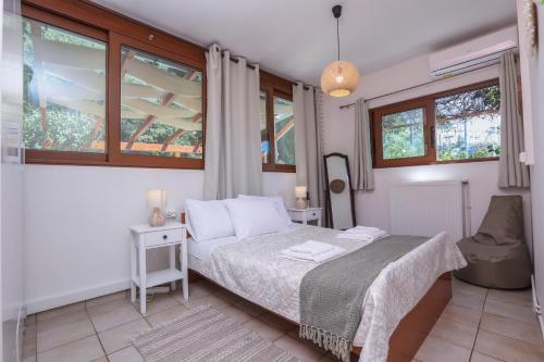 1 dormitorio con 1 cama y 2 ventanas en ΒeΙΙa en Kanoni