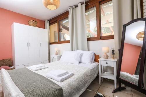 a bedroom with a white bed and a mirror at ΒeΙΙa Kanoni Corfu in Kanoni