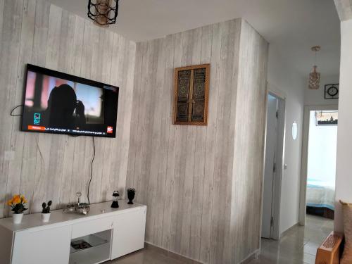 een woonkamer met een televisie aan de muur bij Havre de Paix chez Lamine in El Harhoura