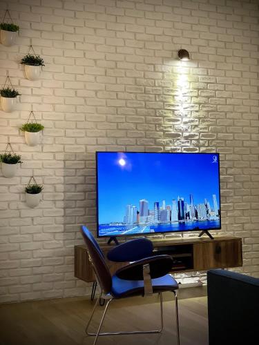 Une grande télévision à écran plat est installée au-dessus d'une table. dans l'établissement Hypercentre de Vienne appartement contemporain proche LYON, à Vienne