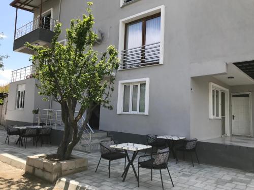 a patio with tables and chairs in front of a building at Bavella House in Pamukkale