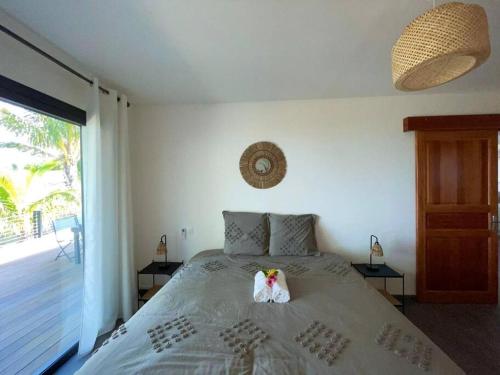 une chambre avec un lit avec deux animaux en peluche dessus dans l'établissement Villa Camomille - Vue grandiose, à Saint-Pierre