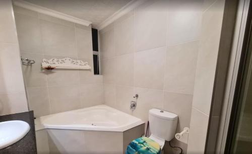a white bathroom with a toilet and a sink at Santorini Unit RR in Margate