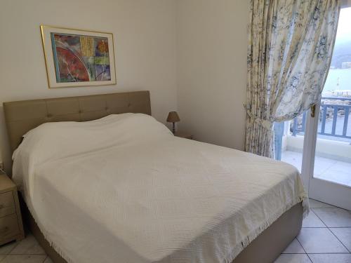 a bedroom with a white bed and a window at Sea view in Karpathos Town
